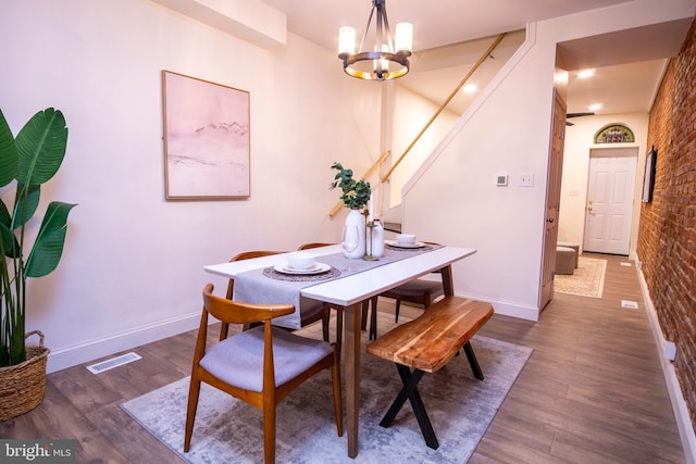 dining area with visible vents, an inviting chandelier, baseboards, and wood finished floors