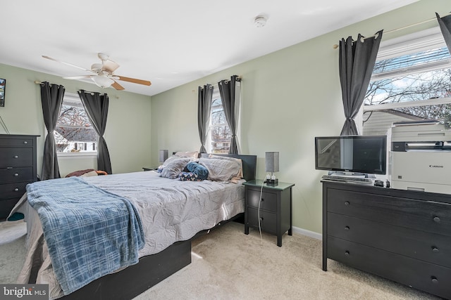 bedroom featuring light carpet, a ceiling fan, and baseboards