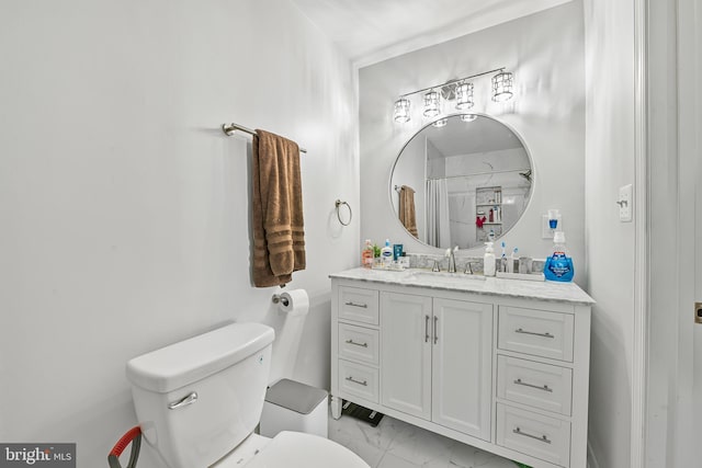 bathroom with toilet, marble finish floor, and vanity