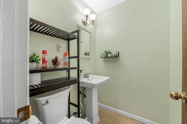 bathroom with toilet, baseboards, and a sink