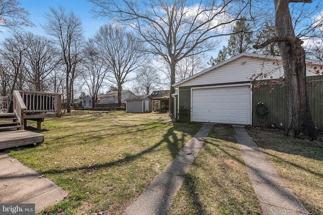 view of yard featuring a deck, an outbuilding, fence, and driveway