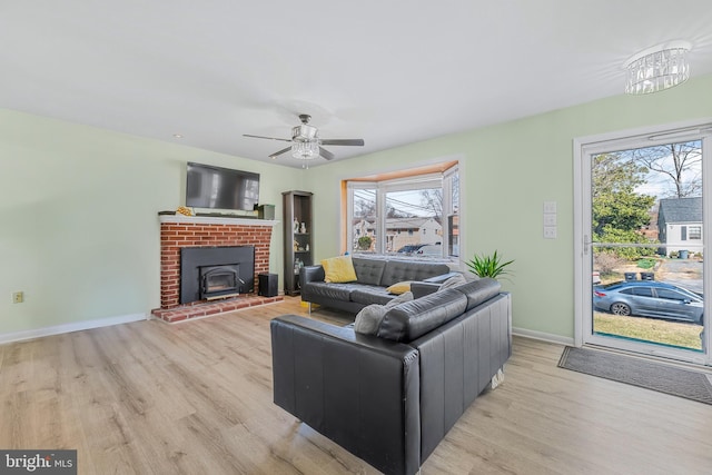 living room featuring plenty of natural light, a ceiling fan, light wood-type flooring, and baseboards