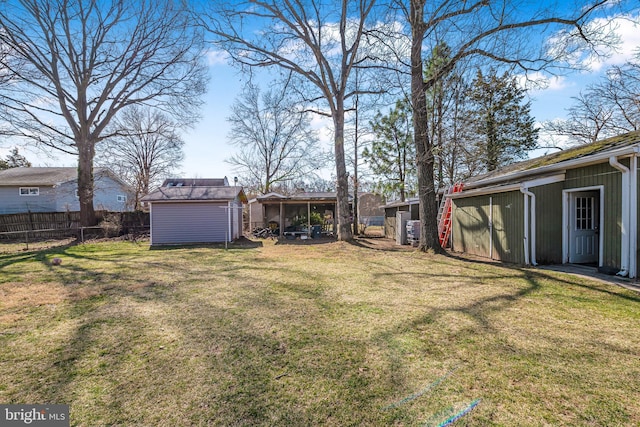 view of yard featuring an outbuilding, a storage unit, and fence