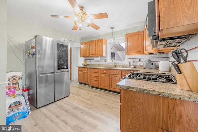 kitchen with a sink, decorative backsplash, smart refrigerator, decorative light fixtures, and light wood-type flooring