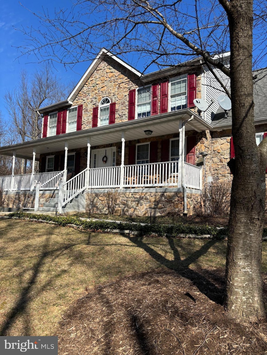 view of front of home with stone siding and covered porch