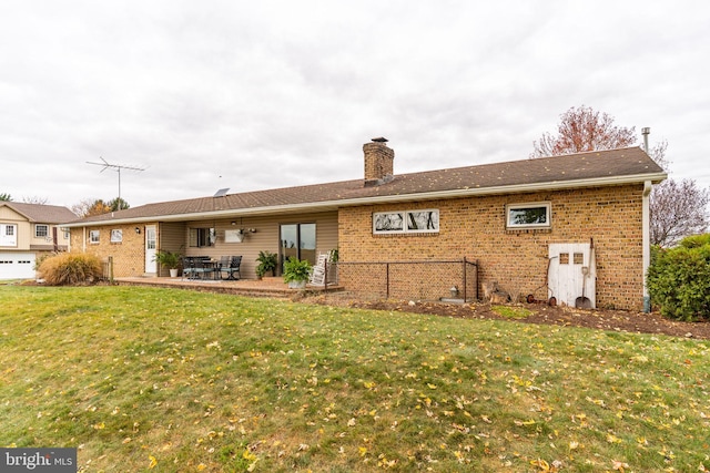 back of house with a patio, fence, a yard, a chimney, and brick siding