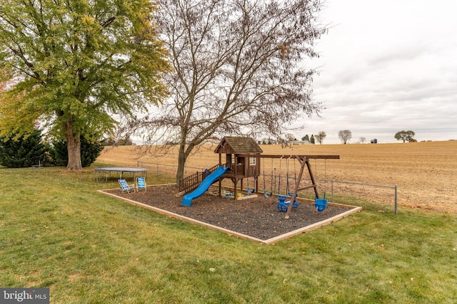 view of jungle gym featuring a trampoline, fence, and a lawn