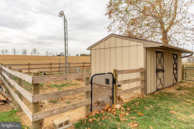 view of outbuilding featuring an outbuilding, a rural view, and fence