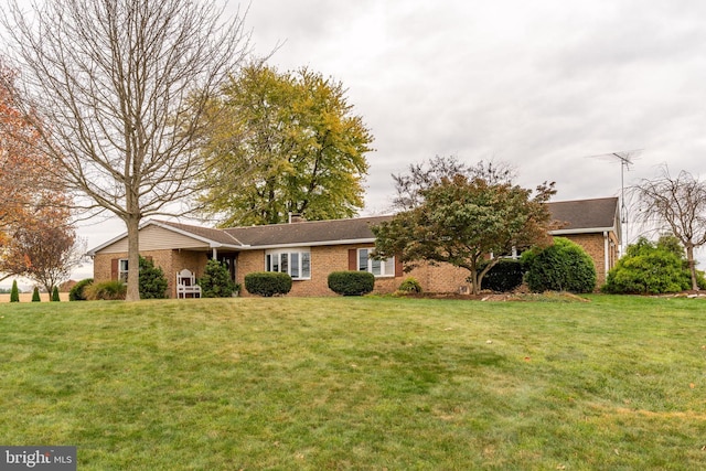 view of front facade with brick siding and a front lawn