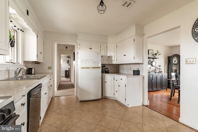 kitchen featuring visible vents, a sink, freestanding refrigerator, light countertops, and dishwasher