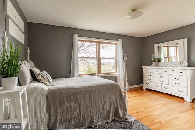 bedroom with light wood-style flooring and baseboards