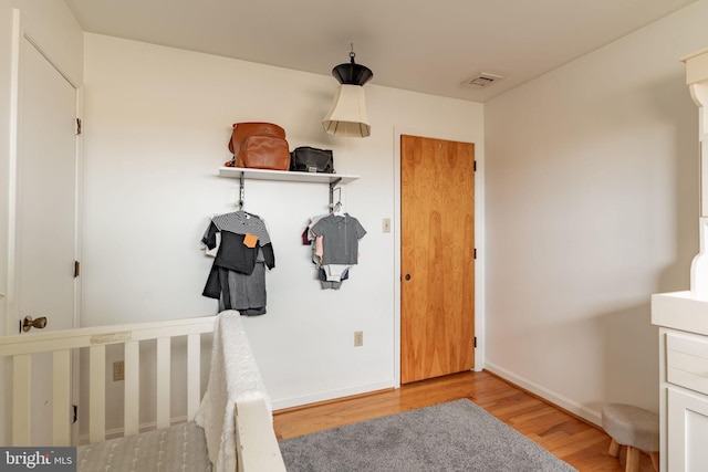 bedroom featuring visible vents, baseboards, and wood finished floors