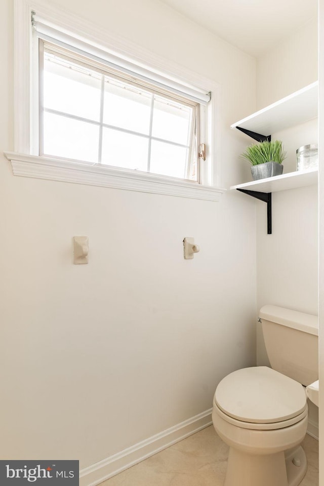 bathroom with toilet and baseboards