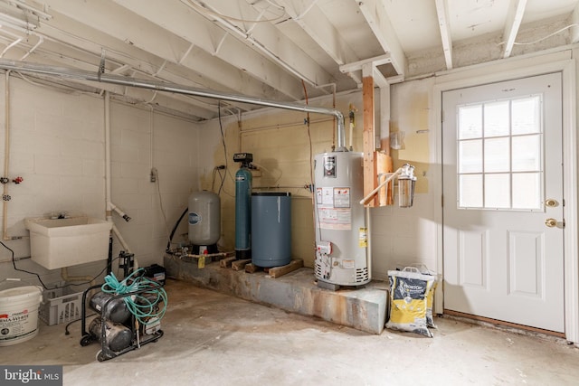 utility room with gas water heater and a sink