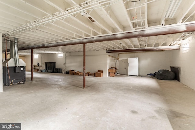 garage featuring heating unit and freestanding refrigerator