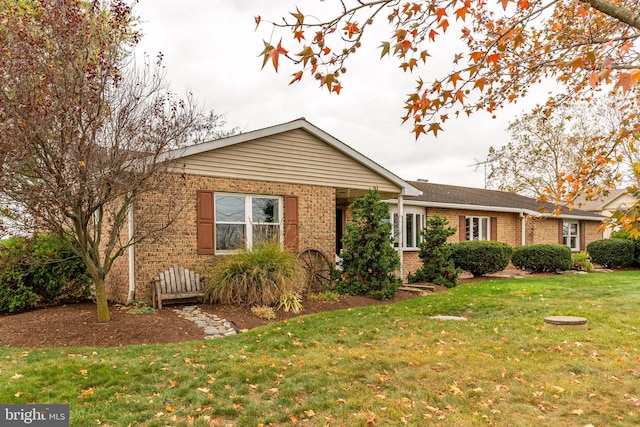 ranch-style home featuring brick siding and a front lawn