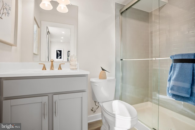 bathroom with a shower stall, toilet, and vanity