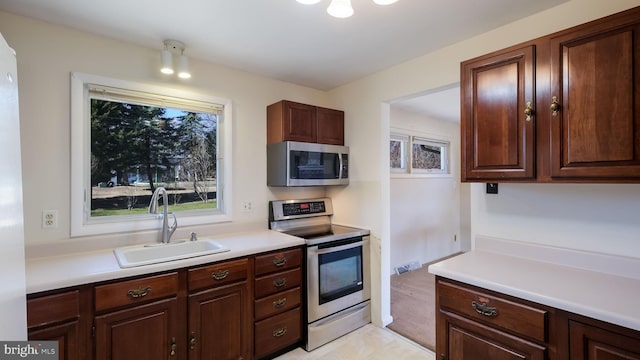 kitchen with stainless steel appliances, light countertops, and a sink