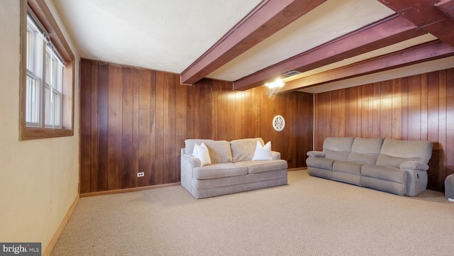 carpeted living room featuring baseboards, beam ceiling, and wood walls