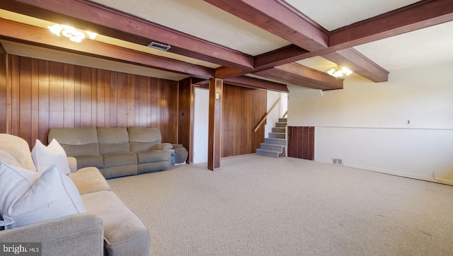 living room with visible vents, beam ceiling, stairway, carpet floors, and wood walls