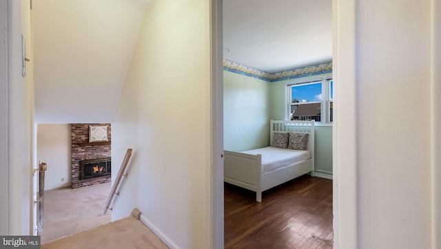 hall featuring wood finished floors, carpet flooring, an upstairs landing, and baseboards