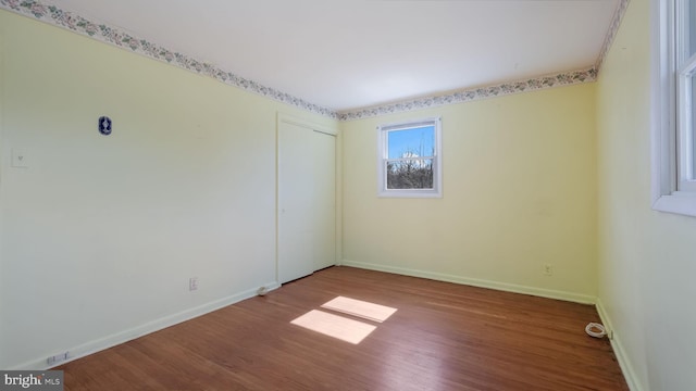 empty room with baseboards and wood finished floors