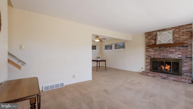 carpeted living area with visible vents and a fireplace