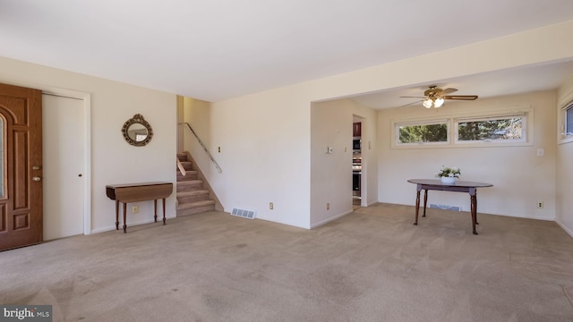 interior space featuring stairway, carpet flooring, visible vents, and ceiling fan