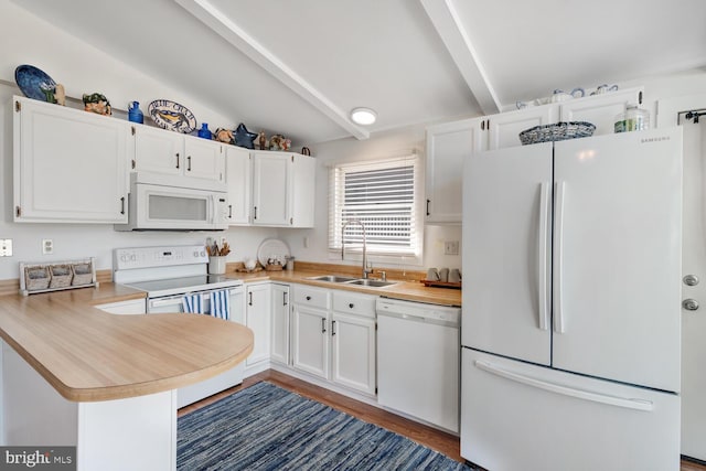 kitchen with white appliances, a peninsula, a sink, light countertops, and white cabinetry