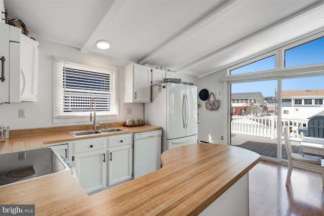 kitchen with vaulted ceiling with beams, butcher block countertops, white cabinets, white appliances, and a sink