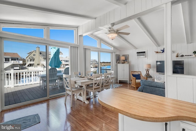 dining room featuring an AC wall unit, vaulted ceiling with beams, a ceiling fan, and wood finished floors