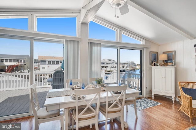 dining room featuring a wealth of natural light, vaulted ceiling with beams, a ceiling fan, and wood finished floors