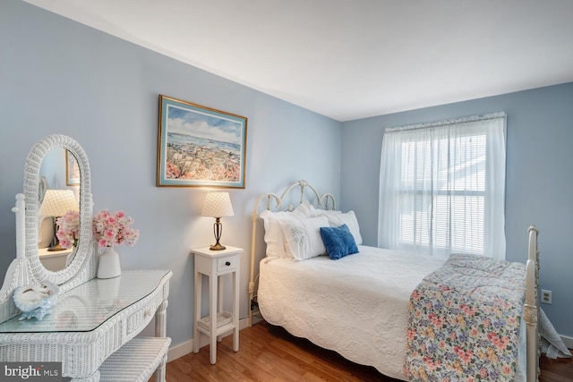 bedroom with wood finished floors and baseboards