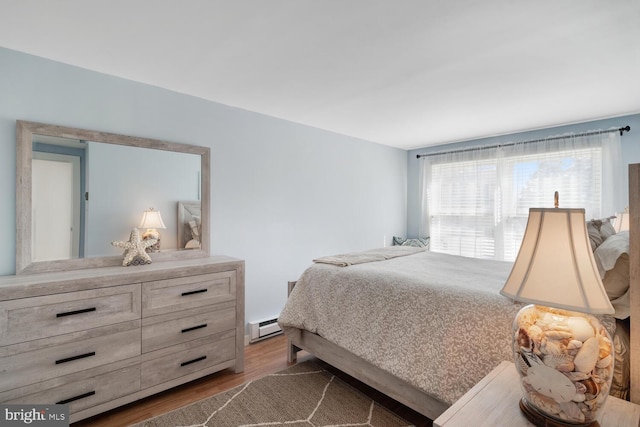 bedroom with a baseboard radiator and wood finished floors