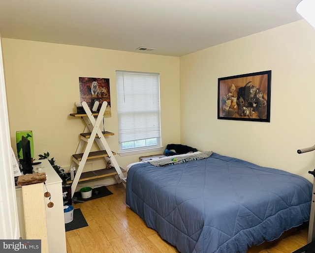 bedroom with light wood finished floors and visible vents