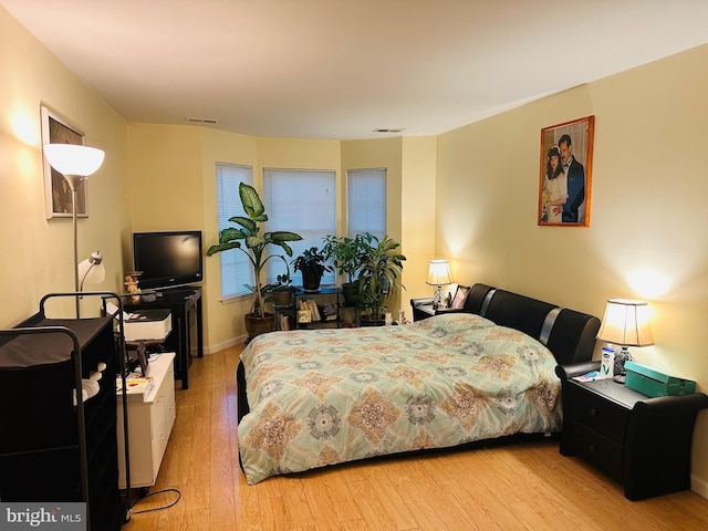 bedroom with visible vents and wood finished floors