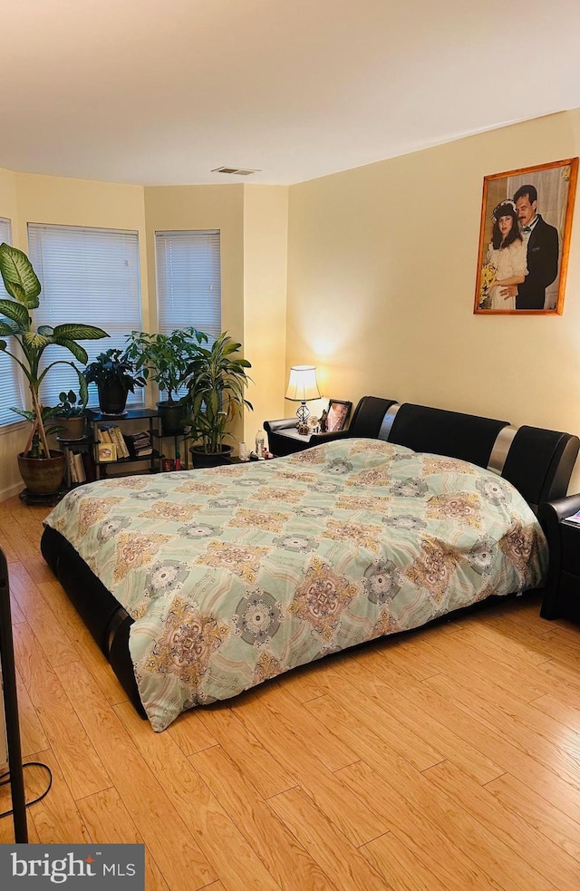 bedroom featuring visible vents and wood finished floors