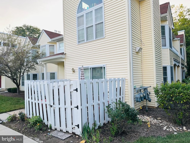 view of side of home featuring a gate and fence