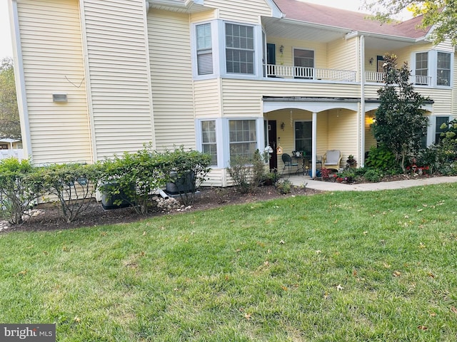 view of front of property with a front lawn and a balcony