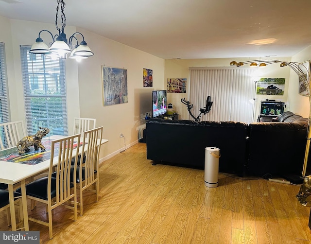 living room with a chandelier, visible vents, baseboards, and light wood-style floors