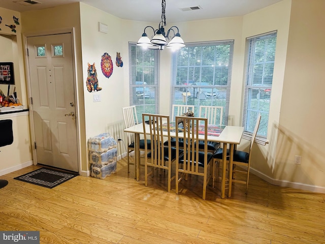 dining room with visible vents, baseboards, a notable chandelier, and wood finished floors