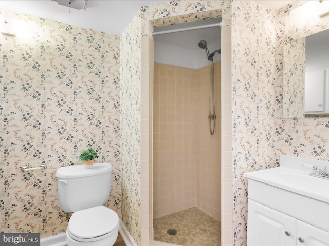 full bath with vanity, toilet, a shower stall, and wallpapered walls