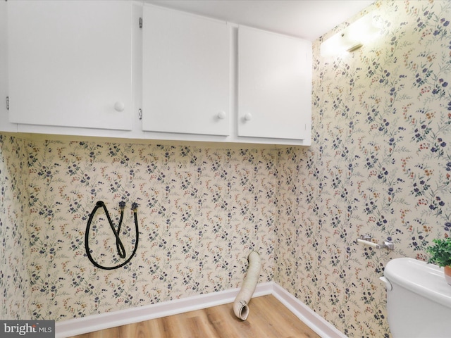 washroom featuring wallpapered walls, laundry area, light wood-style flooring, and baseboards