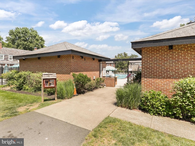 view of home's exterior featuring fence and brick siding