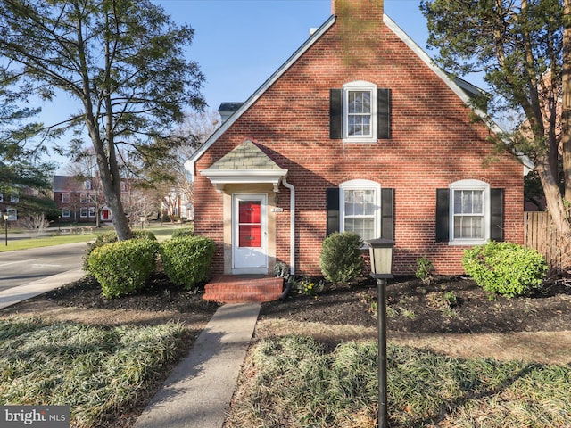 view of front of property featuring brick siding and a chimney