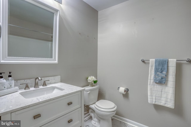 bathroom featuring baseboards, toilet, marble finish floor, and vanity