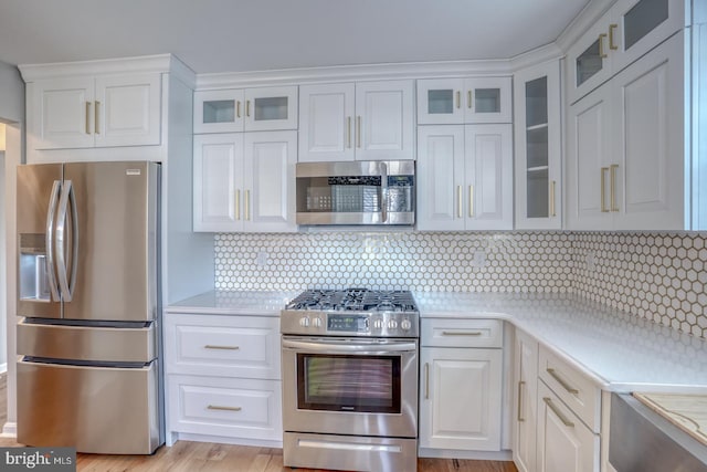 kitchen with white cabinetry, light countertops, and appliances with stainless steel finishes