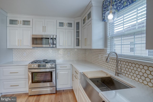 kitchen featuring a sink, light countertops, white cabinets, and stainless steel appliances