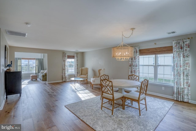 dining area featuring light wood-style flooring, baseboards, and visible vents