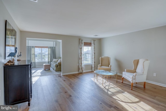 sitting room featuring wood finished floors, baseboards, and a wealth of natural light